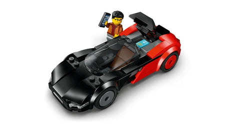 Top angled view of the black and red LEGO City EV Supercar with the roof canopy lifted, showing a minifigure holding a smartphone.
