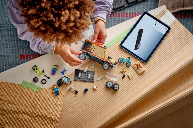 LEGO pieces, part-built van and tablet on a table during the building process