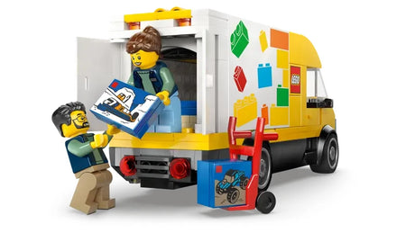 LEGO City The LEGO Van 60500 shown from the rear with cargo area open, hand trolley and pallet visible, and two minifigures unloading a blue LEGO box
