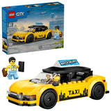 LEGO City yellow taxi model shown in front of the LEGO City retail box, with black roof, white roof sign reading “BRICKSBURG”, black wheels, TAXI text and skyline graphic on the side, and a minifigure standing beside the front of the car with suitcases.