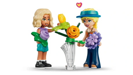 LEGO Friends mini-dolls holding flowers beside a flower vase