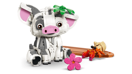 LEGO Disney Pua pig sitting beside a brown raft with an orange hermit crab, green leaf decoration on its head and a separate pink flower in the foreground.