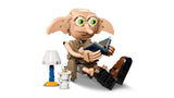 LEGO Dobby figure seated with a blue book beside a lamp and white bottle accessory