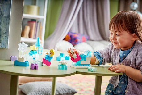 Child playing at a table with LEGO DUPLO Frozen Creative Box pieces, Elsa and Olaf