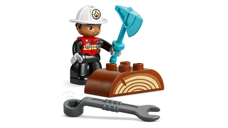 LEGO DUPLO firefighter figure holding a blue axe beside a brown log piece in a chopping pose, with a grey wrench in front of the log.