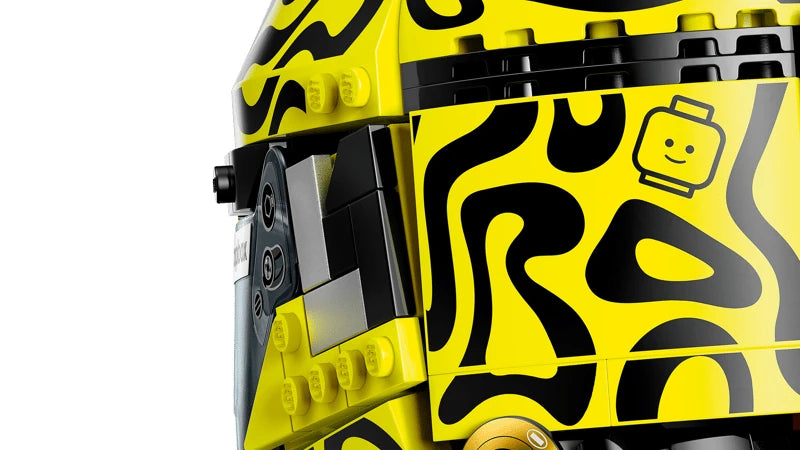 Close view of the fluorescent yellow and black patterned side of the LEGO Lando Norris Helmet with a small LEGO head graphic and black hinge details