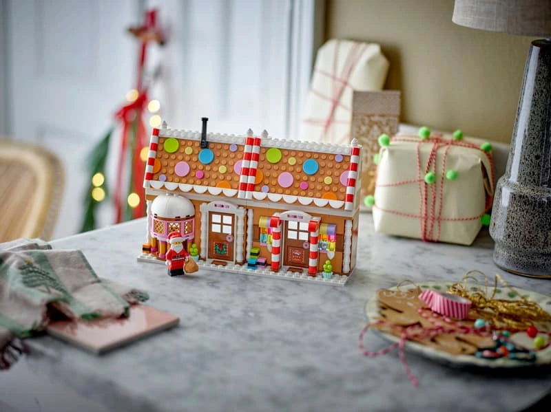 LEGO Festive Gingerbread House 40809 displayed open across the front on a table with Santa minifigure and wrapped gifts