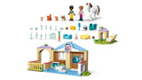 LEGO Friends Animal Vet Clinic pieces laid out showing minidolls, horse, dog, bunny, cats, accessories and build sections arranged above the clinic
