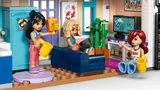 LEGO Friends Liann's Family House 42687 living room with three minidolls, blue sofa, television, indoor plants, watering can and colourful furniture.