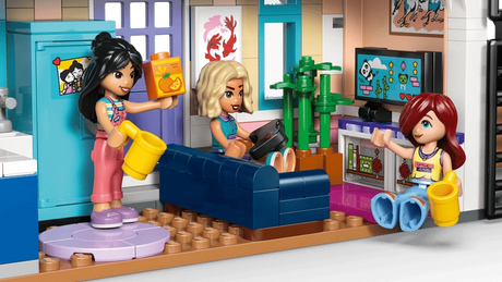 LEGO Friends Liann's Family House 42687 living room with three minidolls, blue sofa, television, indoor plants, watering can and colourful furniture.