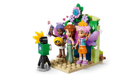 LEGO Friends photo booth scene with three minidolls, camera, flowers and fairy wings