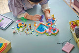 Child building LEGO Friends Fun Water Park Day with pieces and instructions on the floor