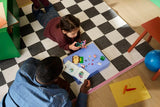 Child playing with LEGO Bluey pieces, purple car build and instruction booklet