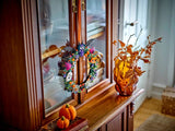 LEGO Halloween Wreath 40825 hanging from a wooden cabinet beside autumn decorations