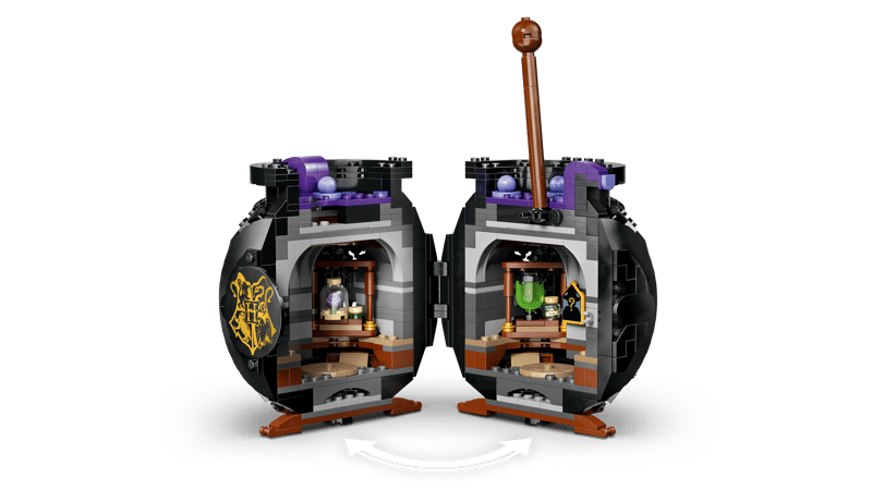 Black LEGO cauldron opened into two hinged halves revealing interior classroom with shelves, potion bottles, green and purple elements and curved arrow graphic below