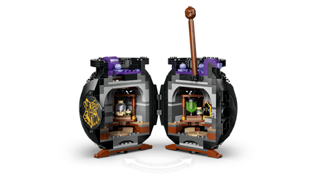 Black LEGO cauldron opened into two hinged halves revealing interior classroom with shelves, potion bottles, green and purple elements and curved arrow graphic below
