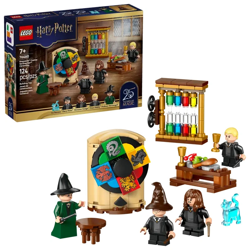 LEGO Harry Potter Hogwarts Castle Sorting Hat Ceremony set showing retail box beside the assembled sorting wheel build, table, accessories and minifigures on a white background

