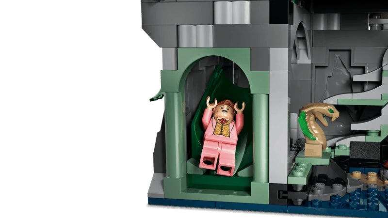 LEGO Hogwarts castle section with pink minifigure in a green doorway and a green snake figure in the lower chamber