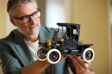 Man holding the completed LEGO Icons Ford Model T with black bodywork, gold front details, white tyres and black fabric roof