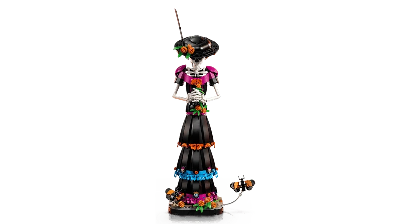 Front view of the LEGO Ideas La Catrina 21372 figure with hands clasped and butterflies beside the floral base
