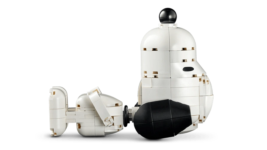 LEGO Snoopy figure lying horizontally with his white body, black ear and nose visible, shown separately from the doghouse.
