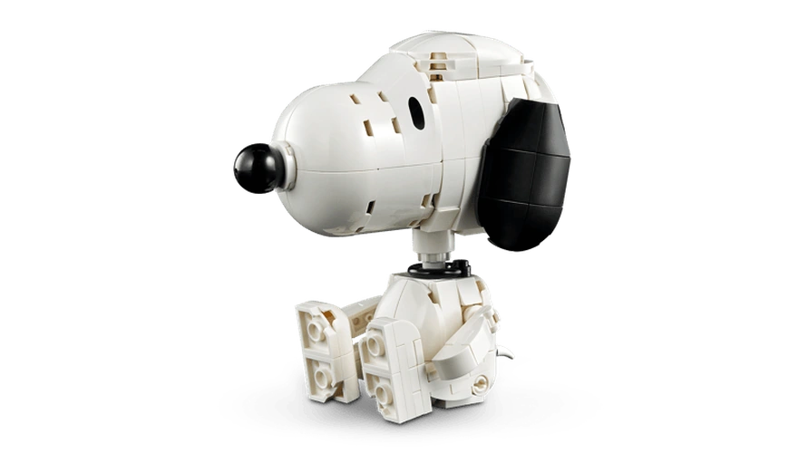 Seated LEGO Snoopy figure shown on its own with a white body, large black ear and nose, and bent legs.