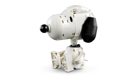 Seated LEGO Snoopy figure shown on its own with a white body, large black ear and nose, and bent legs.