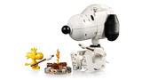 LEGO Snoopy seated opposite yellow Woodstock beside a small campfire, with both characters holding roasting sticks.