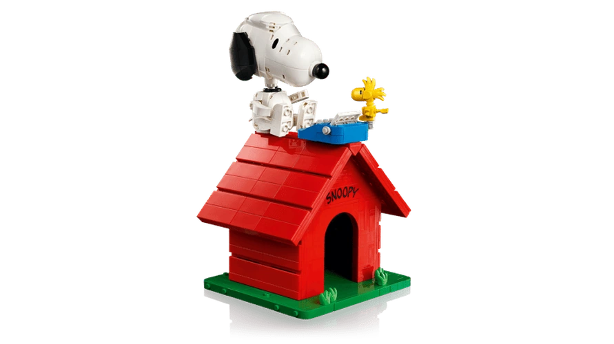 Completed brick built LEGO Snoopy's Doghouse with Snoopy seated on the roof beside yellow Woodstock and a blue typewriter.