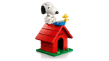 Completed brick built LEGO Snoopy's Doghouse with Snoopy seated on the roof beside yellow Woodstock and a blue typewriter.