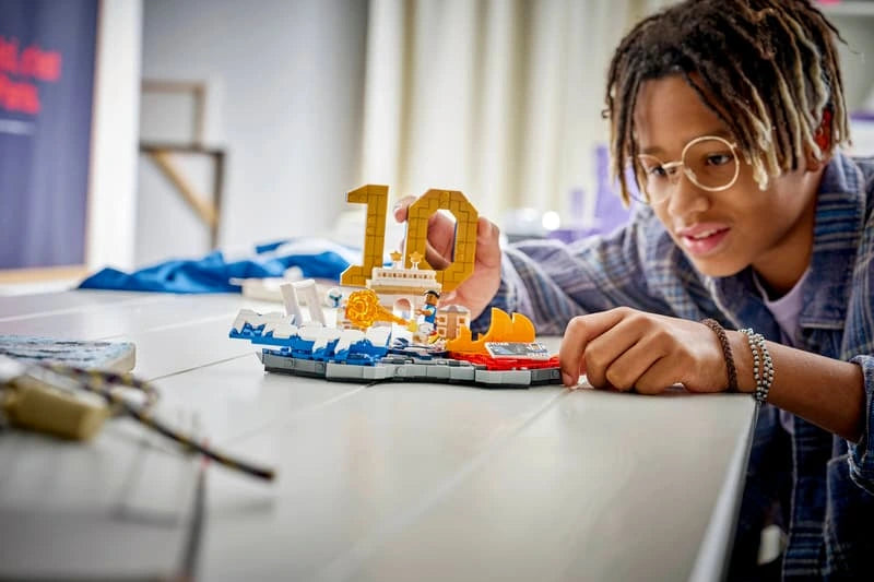 Child assembling the LEGO Editions Kylian Mbappé Football Highlights model on a table