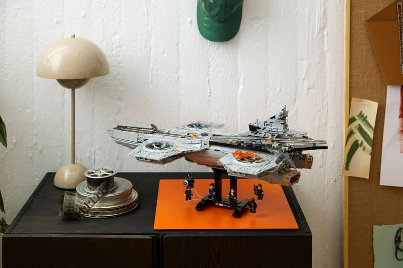 LEGO Marvel S.H.I.E.L.D. Helicarrier displayed on a cabinet above an orange mat with minifigures beneath the model