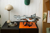 LEGO Marvel S.H.I.E.L.D. Helicarrier displayed on a cabinet above an orange mat with minifigures beneath the model