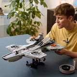 Man holding the completed LEGO Marvel S.H.I.E.L.D. Helicarrier above its black display stand and minifigures