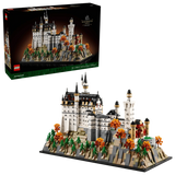 LEGO Neuschwanstein Castle 21063 box shown above the completed castle model with landscaped base, pine trees and orange autumn trees on a black background