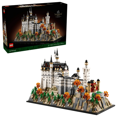 LEGO Neuschwanstein Castle 21063 box shown above the completed castle model with landscaped base, pine trees and orange autumn trees on a black background