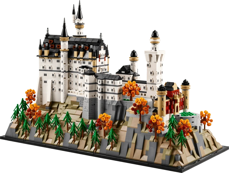 LEGO Neuschwanstein Castle 21063 model in angled view showing the white castle, towers, landscaped rocky base, pine trees and orange autumn trees