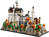 LEGO Neuschwanstein Castle 21063 model in angled view showing the white castle, towers, landscaped rocky base, pine trees and orange autumn trees