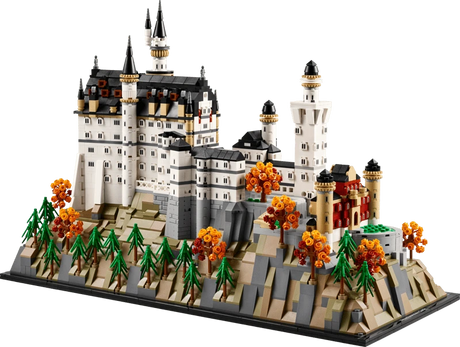 LEGO Neuschwanstein Castle 21063 model in angled view showing the white castle, towers, landscaped rocky base, pine trees and orange autumn trees