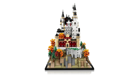 LEGO Neuschwanstein Castle 21063 end view showing the castle rising behind the front buildings, rocky base, pine trees and orange autumn trees