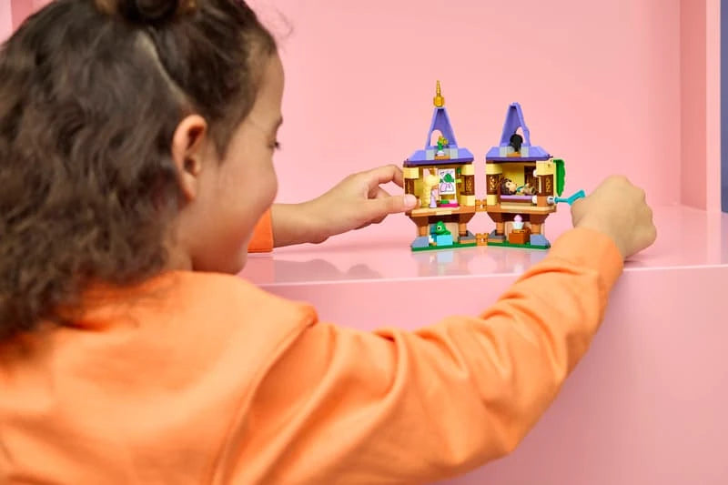 Child playing with LEGO Rapunzel's Mini Tower on a pink table