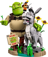 Close-up of LEGO Shrek, Donkey & Puss in Boots 72423 featuring Shrek holding an onion, Donkey, Puss in Boots, sunflowers and the Beware Ogre sign.