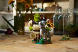 LEGO Shrek, Donkey & Puss in Boots 72423 assembled model displayed on a wooden table with sunflowers and a Beware Ogre sign.