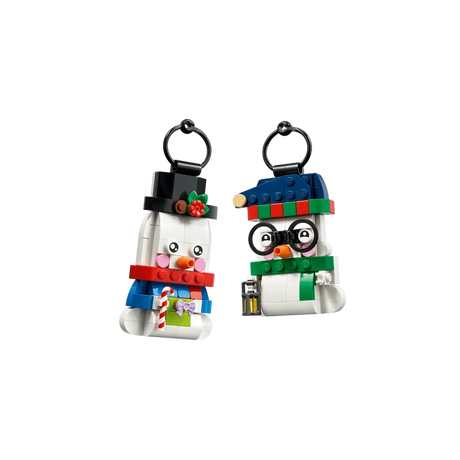 Two LEGO snowman ornaments with black hanging loops, one wearing glasses and a blue hat and one in a black top hat
