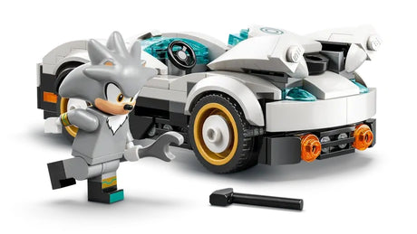 Close view of Silver’s white race car with fins, gold wheel rims, front lights and a wrench accessory placed on the ground in front of the vehicle
