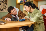 Child playing with the LEGO Speed Champions Jaguar Project 7 and Land Rover Defender 77264 models at a table