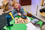 Child building a LEGO Marvel prison transport set at a table with vehicle parts, minifigures and tablet instructions