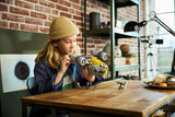Woman holding the LEGO Star Wars The Razor Crest above a wooden table with Grogu and minifigures positioned below