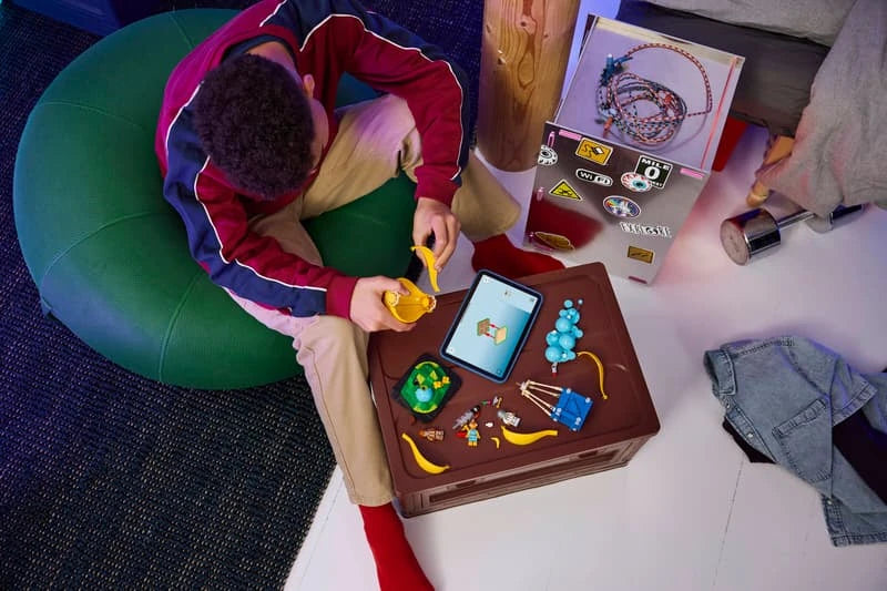 Child building a LEGO Fortnite supply drop set at a table with pieces, minifigures and tablet instructions