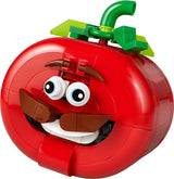 Close-up of LEGO red tomato head model with green stem, eyebrows, eyes, moustache and smiling mouth